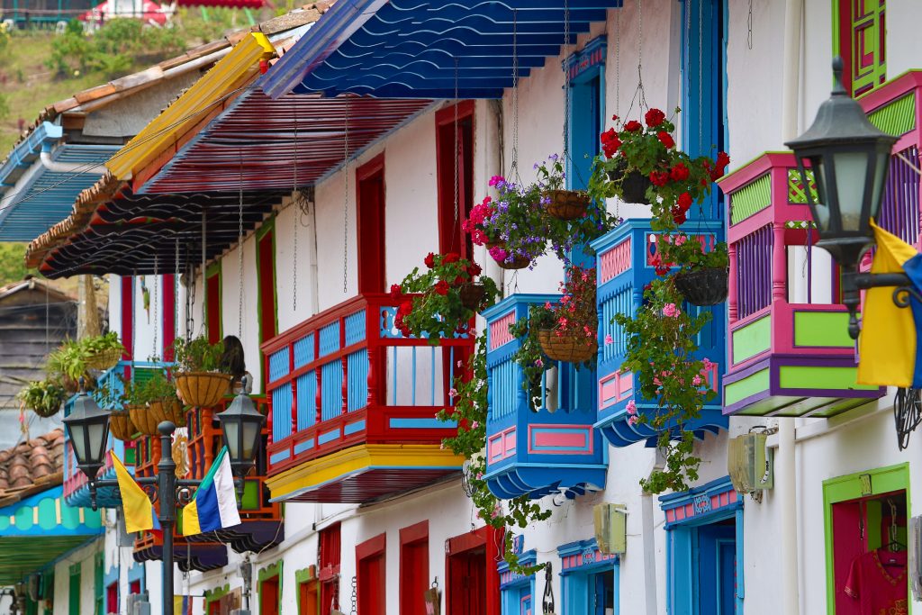 Balcones tradicionales de colores, flores y banderas colombianas.